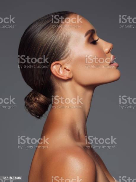 Beautiful woman with makeup posed with head tilted up.